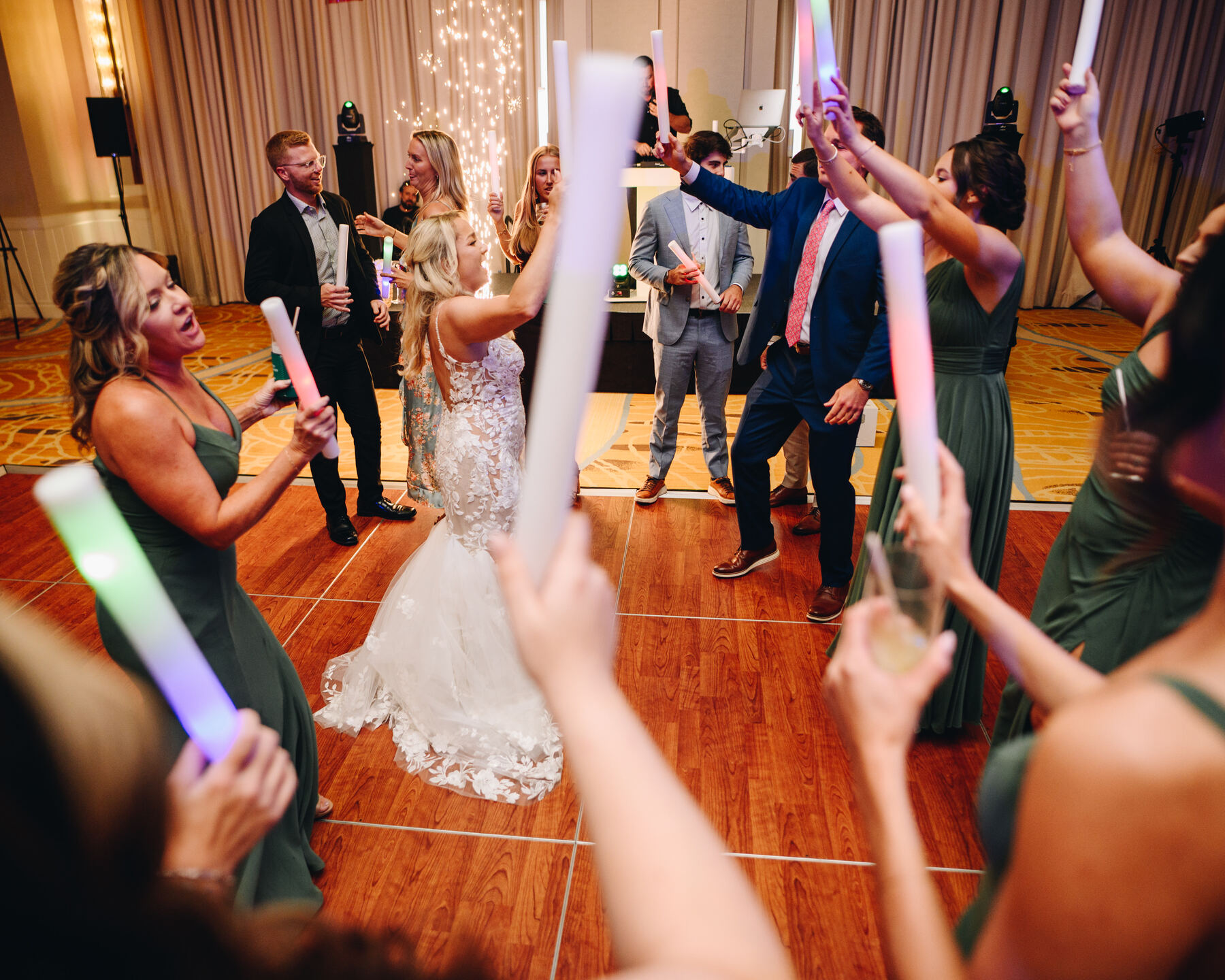 Guests waving glow sticks on a packed dance floor